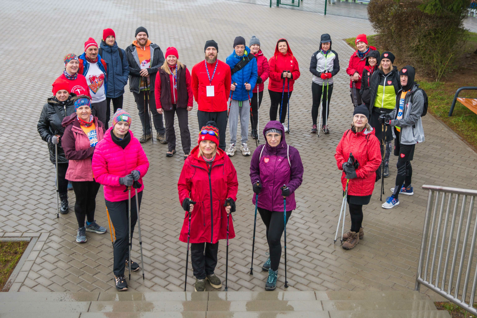 grupa ludzi z kijkami do nordic walking stoi na placu